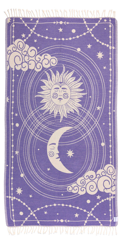 Towel with celestial design featuring sun, moon, and stars on a purple background