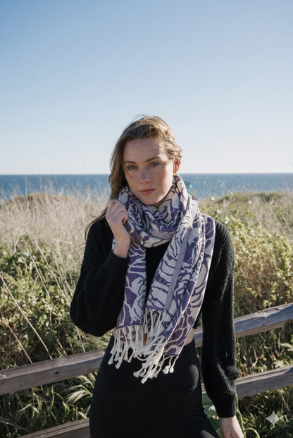 Woman wearing a patterned scarf outdoors with ocean in the background