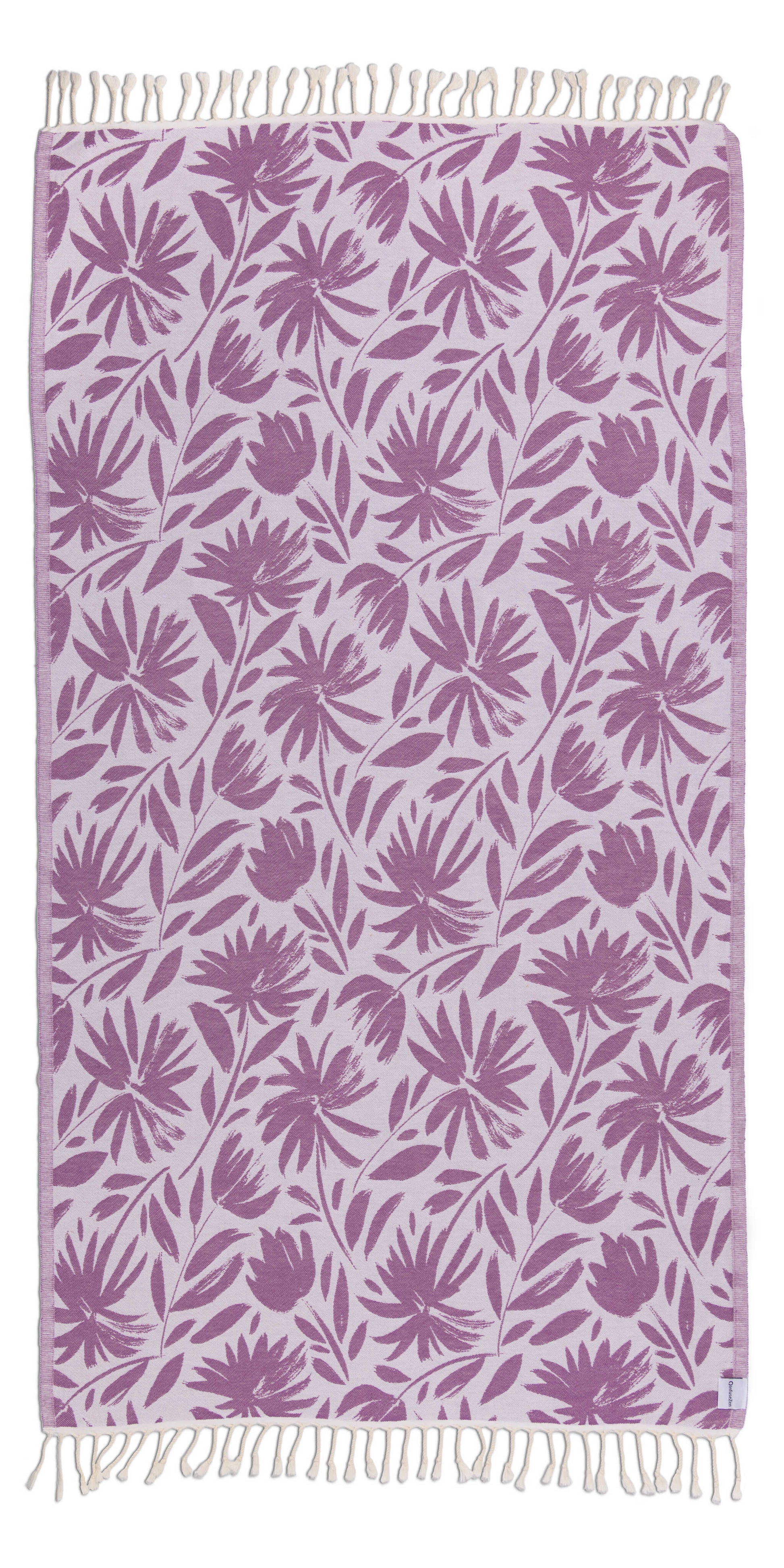 Towel with purple floral pattern and white fringe on a white background